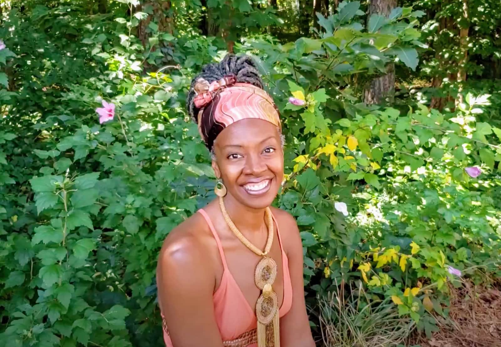 Althea Lawton-Thompson smiling outdoors in green foliage