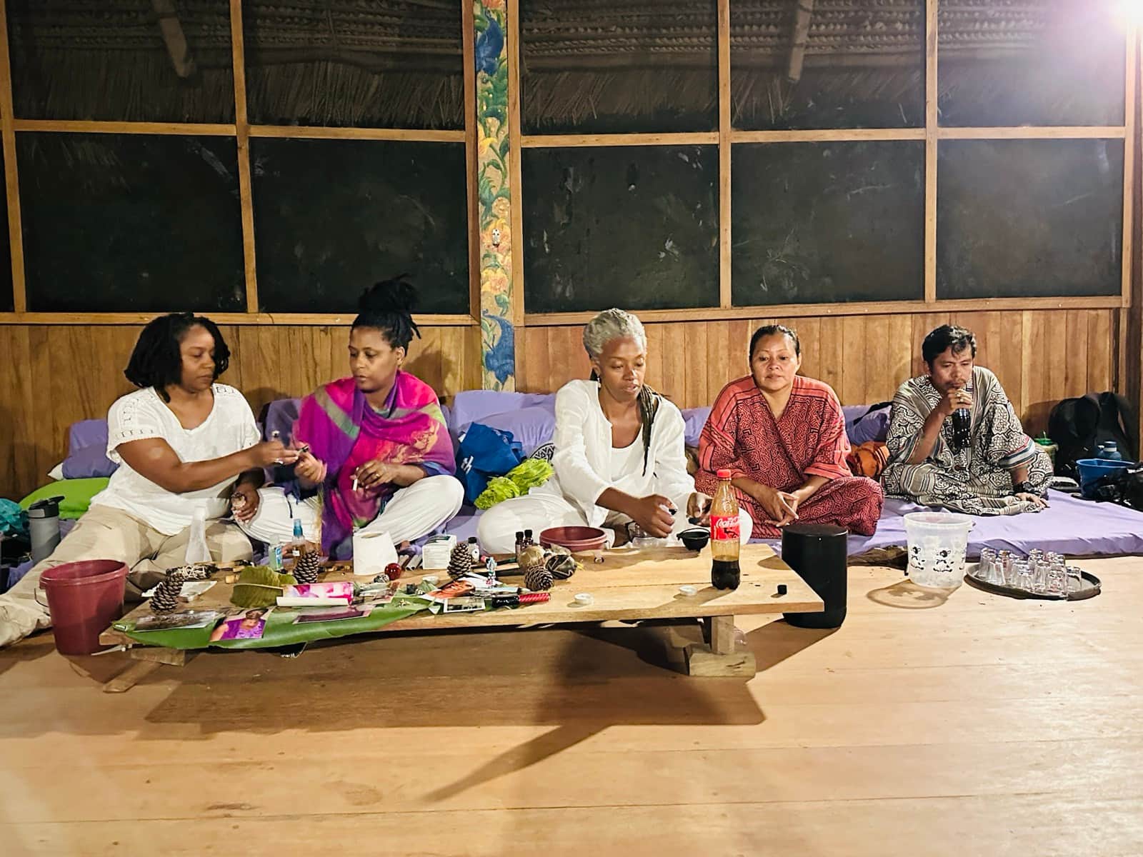 PMFT participants preparing ceremonial materials together inside a wooden gathering space